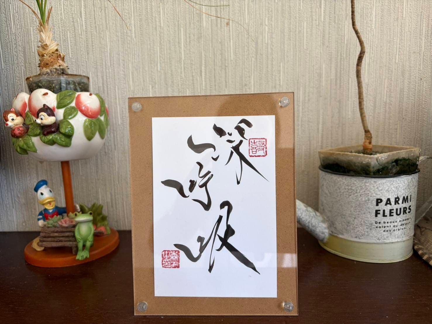 玄関に飾られた「深呼吸」の書。置物や花とともに